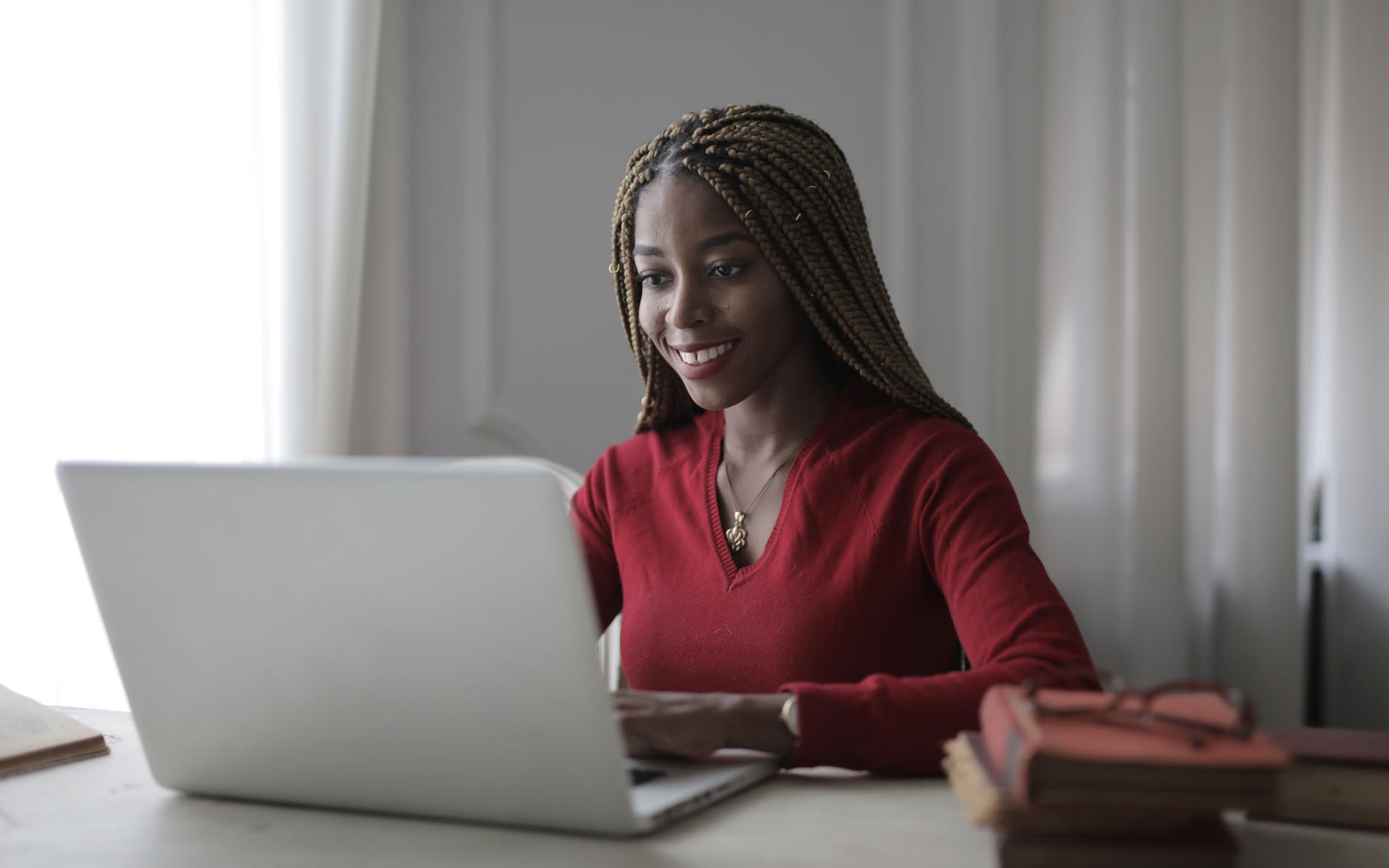 woman in red long sleeve shirt using macbook